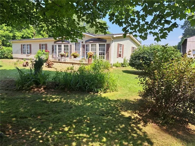 a front view of a house with a yard and lake view