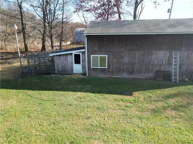 a view of a yard in front of a house with a large tree