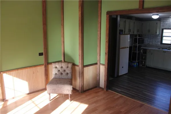 a view of a hallway with wooden floor and a living room