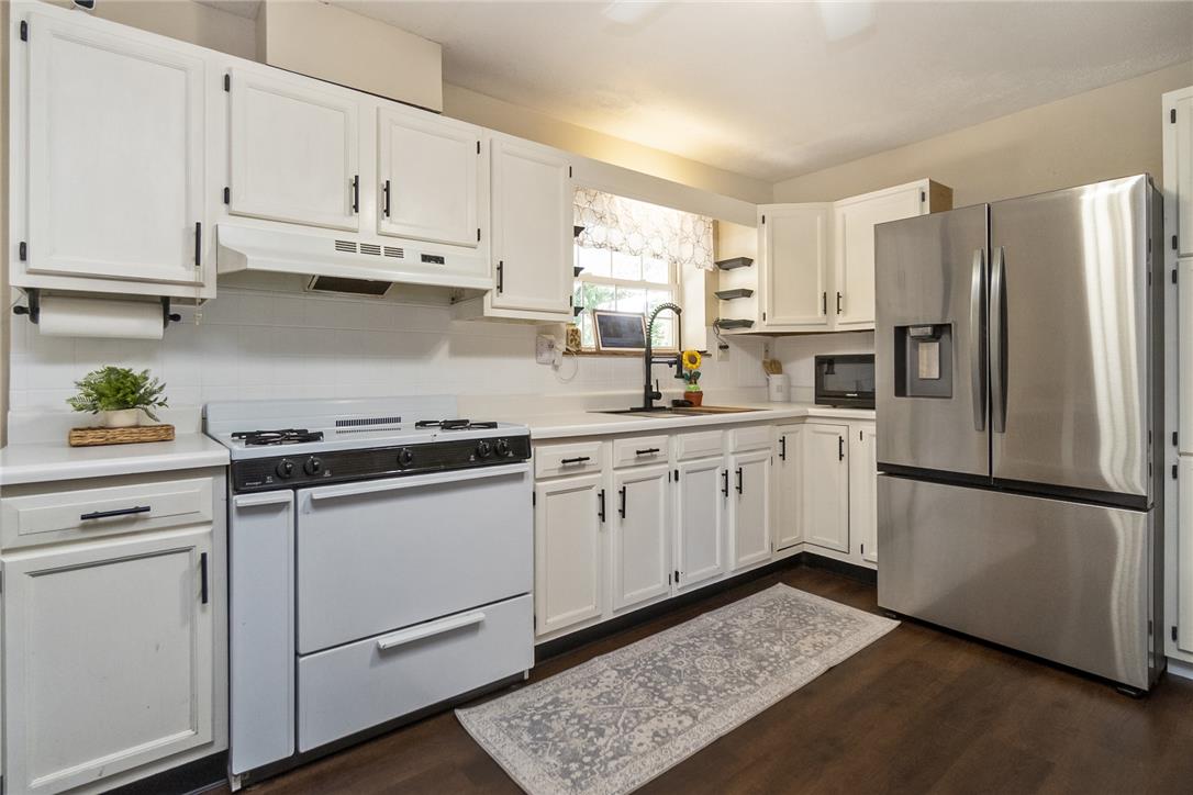 331 East Lizard Creek Road Lehighton, PA 18235 - Photo 20 of 37 White cabinetry with dark pulls frames this bright kitchen, offering ample storage and a clear view of the outdoors through a charming window.