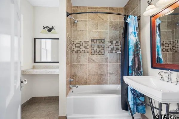 a bathroom with a tub sink and mirror