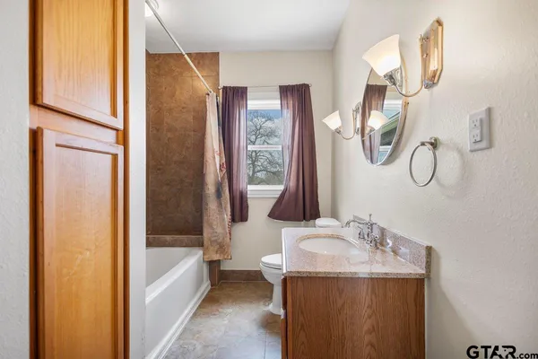 a bathroom with a sink a toilet and a window