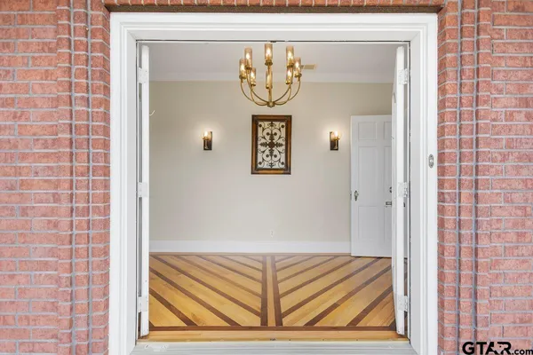 a view of a livingroom with wooden floor and a ceiling fan