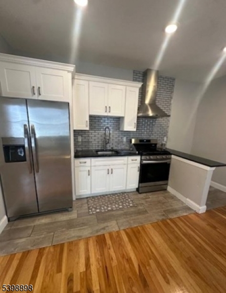 474 10th Avenue, Unit 303 Paterson, NJ 07514 - Photo 5 of 13 a kitchen with stainless steel appliances granite countertop a stove a sink and a refrigerator