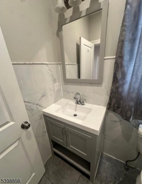 474 10th Avenue, Unit 303 Paterson, NJ 07514 - Photo 9 of 13 a bathroom with a sink and mirror