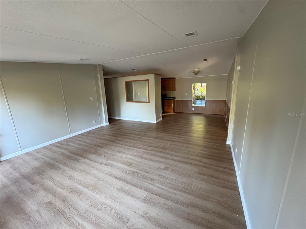 28492 Sentinel Street Nobleton, FL 34661 - Photo 15 of 23 a view of empty room with wooden floor and window