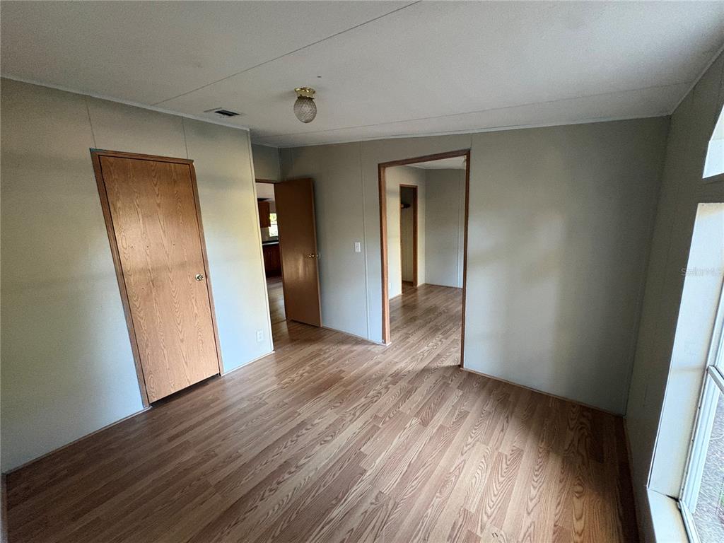 28492 Sentinel Street Nobleton, FL 34661 - Photo 17 of 23 an empty room with wooden floor and closet