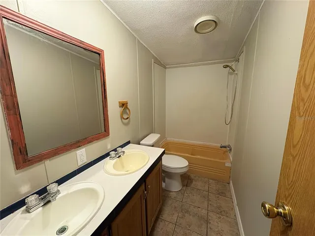 a bathroom with a sink and mirror with toilet