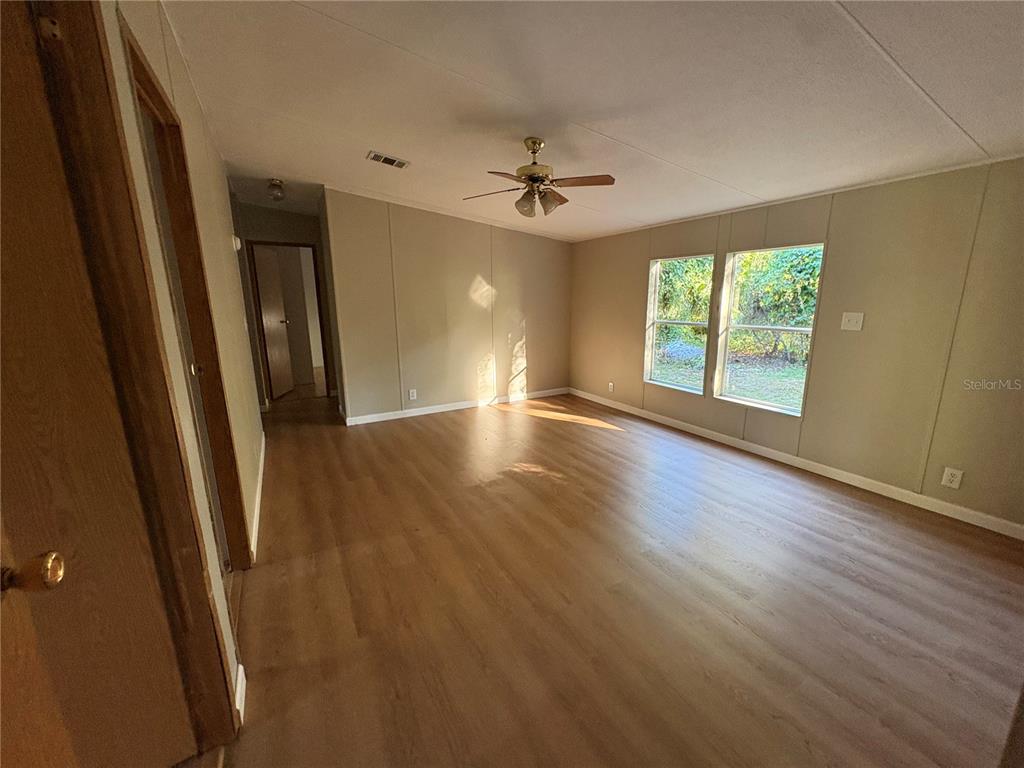 28492 Sentinel Street Nobleton, FL 34661 - Photo 20 of 23 an empty room with wooden floor and windows