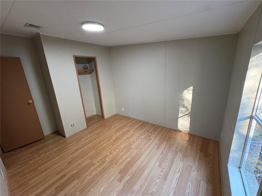 28492 Sentinel Street Nobleton, FL 34661 - Photo 21 of 23 an empty room with wooden floor and windows