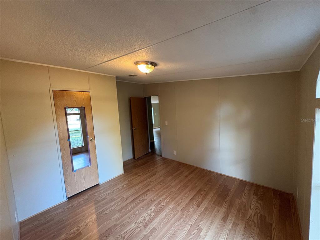 28492 Sentinel Street Nobleton, FL 34661 - Photo 22 of 23 a view of an empty room with wooden floor and a window