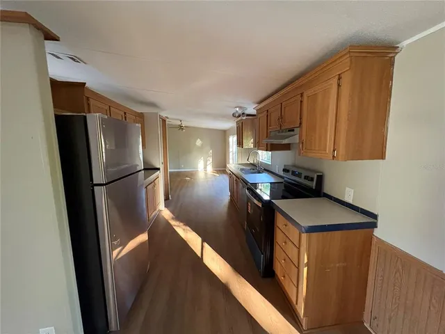 a kitchen with stainless steel appliances granite countertop a refrigerator a sink and a stove