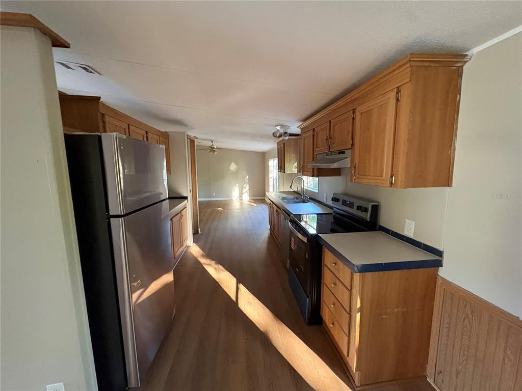 28492 Sentinel Street Nobleton, FL 34661 - Photo 8 of 23 a kitchen with stainless steel appliances granite countertop a refrigerator a sink and a stove