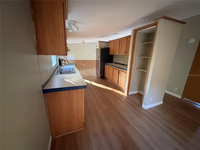 a kitchen with stainless steel appliances wooden floors and wooden cabinets