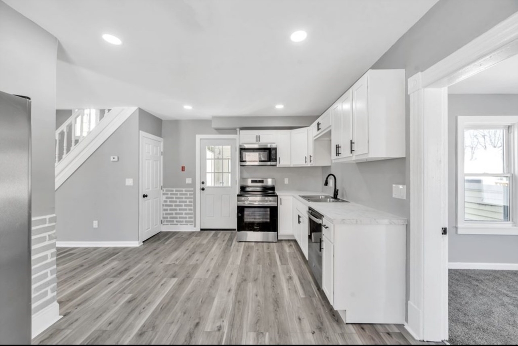 248 Parker Street Springfield, MA 01151 - Photo 6 of 26 a kitchen with granite countertop a stove top oven and cabinets