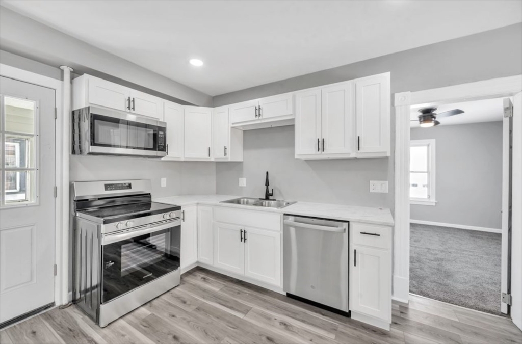 248 Parker Street Springfield, MA 01151 - Photo 8 of 26 a kitchen with stainless steel appliances granite countertop a stove and a sink