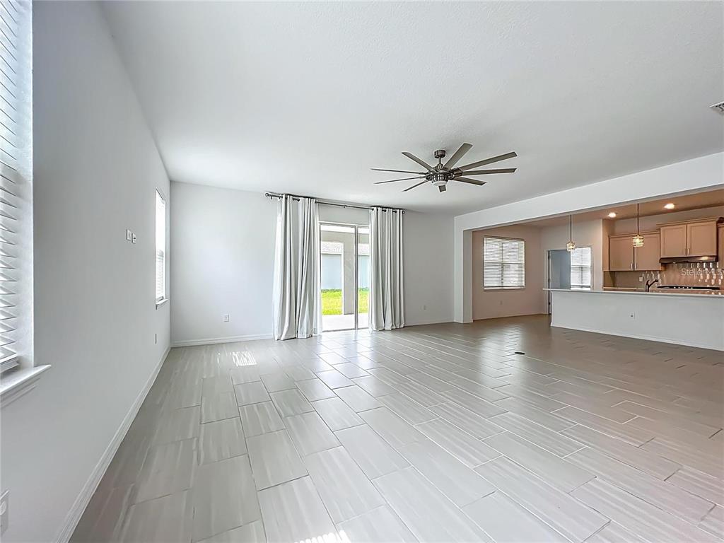7483 Southwest 64th St Road Ocala, FL 34474 - Photo 11 of 74 a view of a livingroom with wooden floor and a ceiling fan