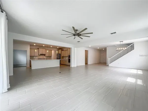 a large kitchen with stainless steel appliances kitchen island granite countertop a stove a sink a refrigerator and a refrigerator