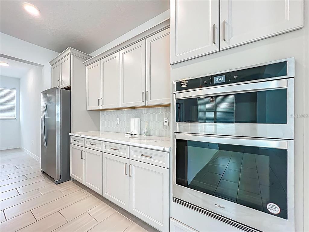 7483 Southwest 64th St Road Ocala, FL 34474 - Photo 18 of 74 a kitchen with white cabinets and stainless steel appliances