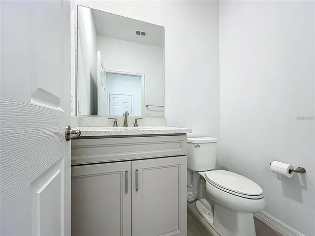 an empty room with ceiling fan and windows