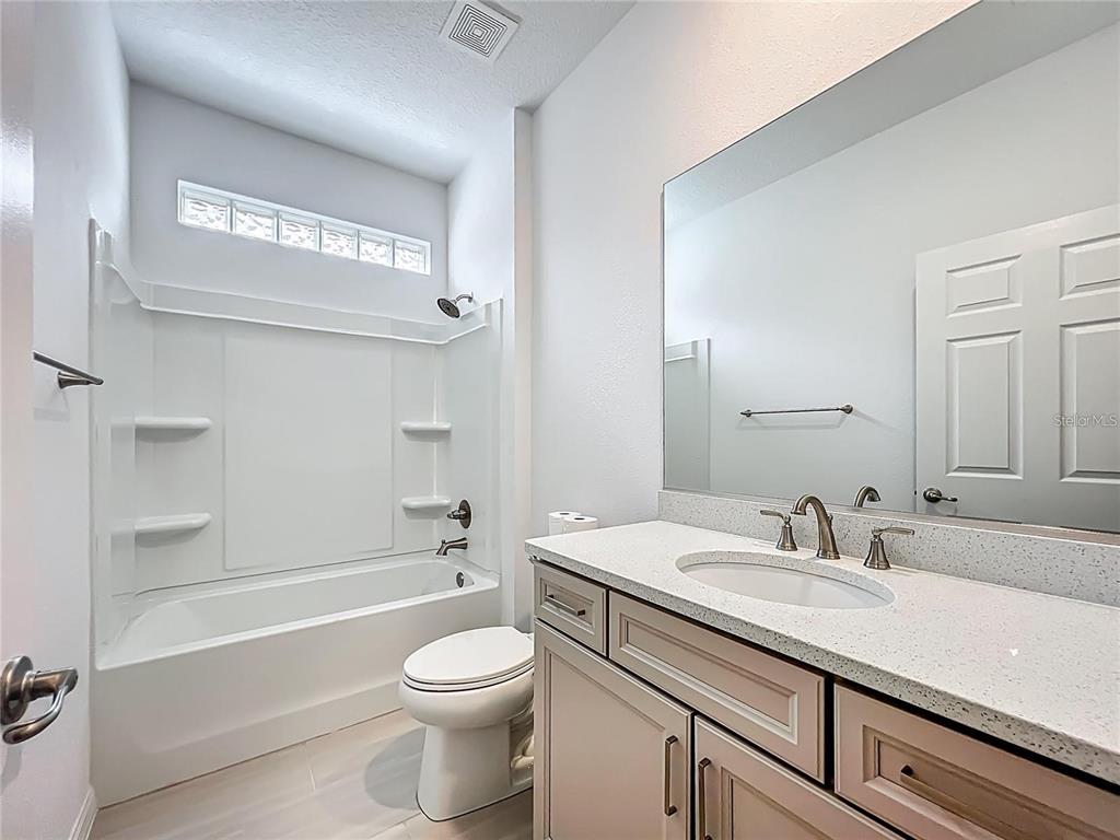 7483 Southwest 64th St Road Ocala, FL 34474 - Photo 28 of 74 a bathroom with a granite countertop toilet a sink and a bathtub