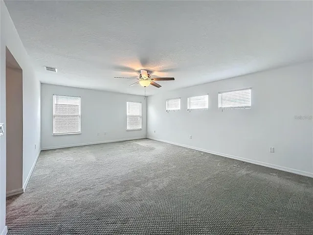 an empty room with closet and a ceiling fan