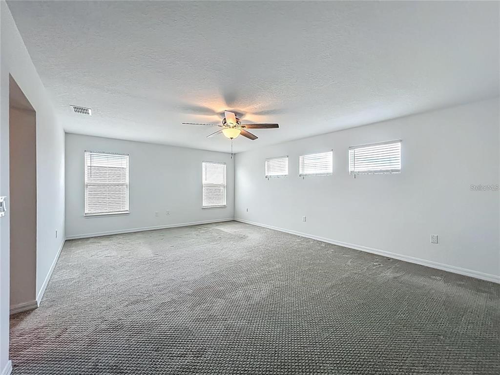 7483 Southwest 64th St Road Ocala, FL 34474 - Photo 39 of 74 an empty room with windows and chandelier fan