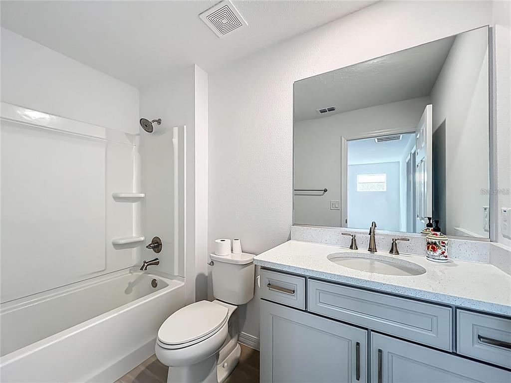 7483 Southwest 64th St Road Ocala, FL 34474 - Photo 49 of 74 a bathroom with a granite countertop toilet a sink and a bathtub