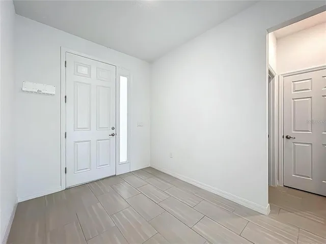 an empty room with windows and white walls