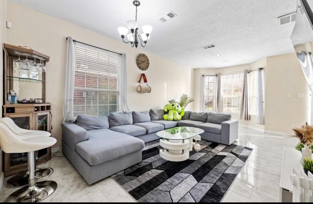 4524 Lodestone Lane Fort Worth, TX 76123 - Photo 2 of 9 Living area featuring a textured ceiling and a chandelier