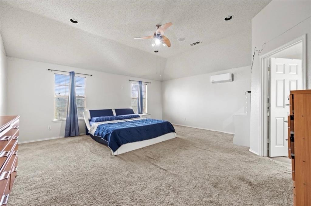 4524 Lodestone Lane Fort Worth, TX 76123 - Photo 5 of 9 Bedroom featuring light carpet, a textured ceiling, ceiling fan, lofted ceiling, and a wall mounted air conditioner
