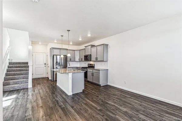 a kitchen with a refrigerator and white cabinets