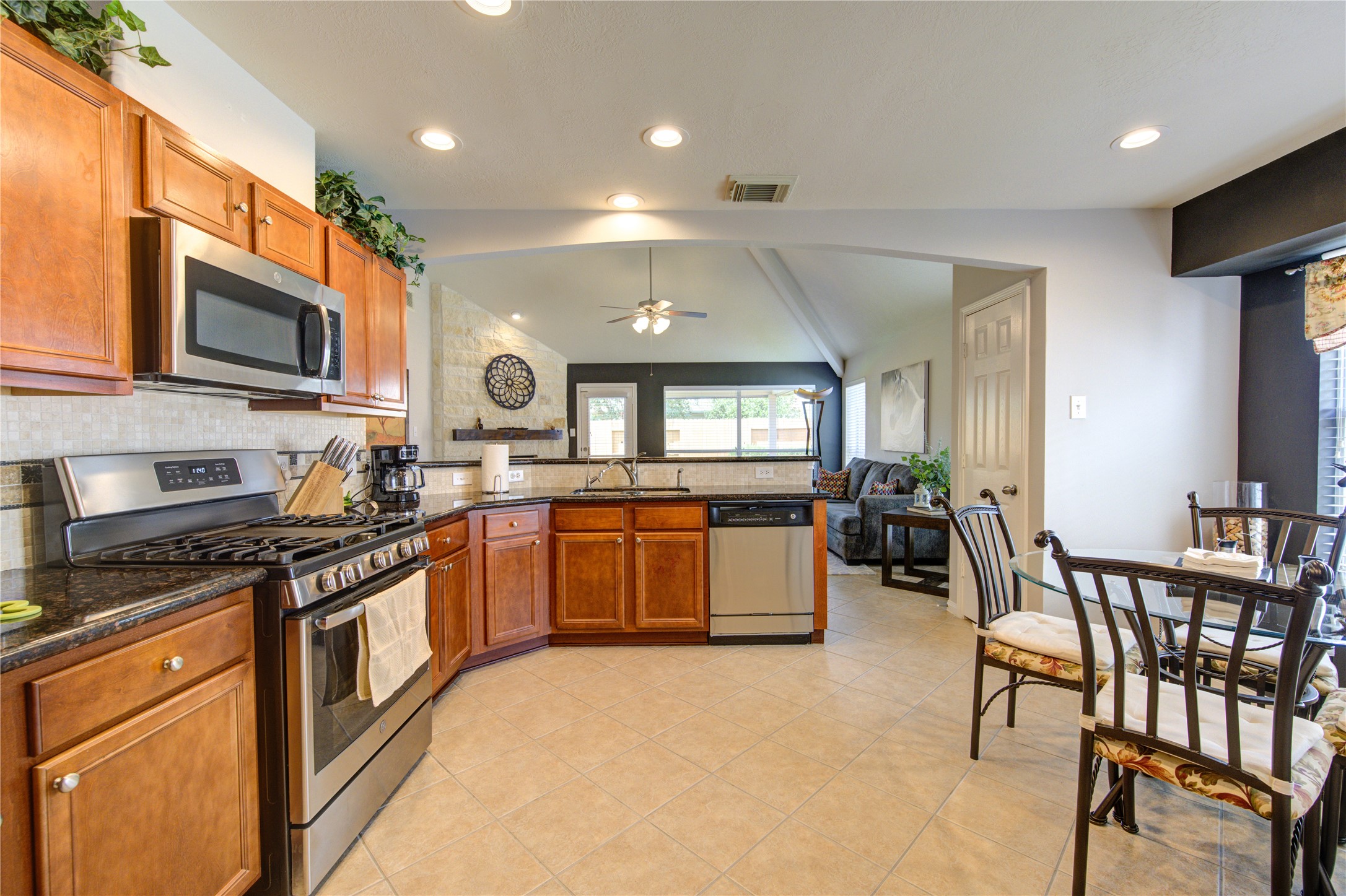 25215 Hazel Ranch Drive Katy, TX 77494 - Photo 13 of 32 a large kitchen with stainless steel appliances granite countertop a stove a sink dishwasher a dining table and chairs with wooden floor