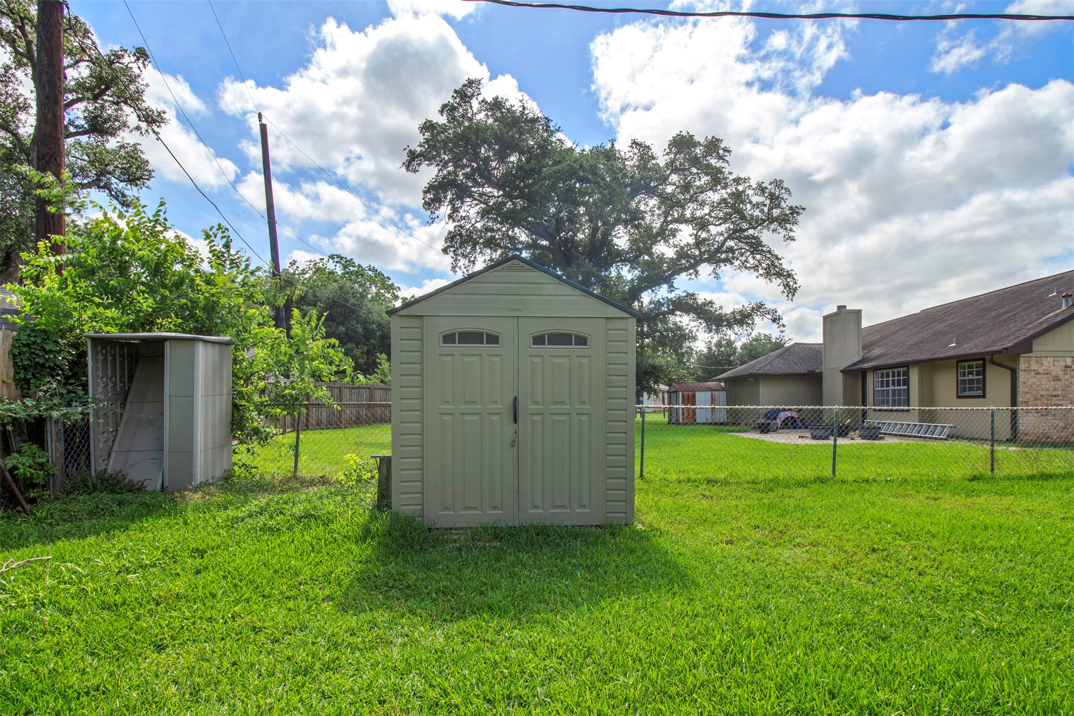 206 Stanford Road Lake Jackson, TX 77566 - Photo 25 of 26 a backyard of a house with wooden fence and large trees