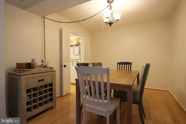 a view of a dining room with furniture a chandelier and wooden floor
