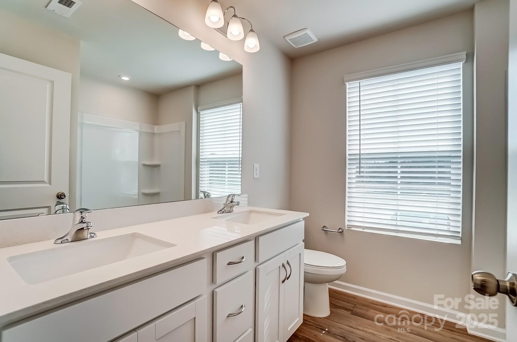 1471 Honey Trail Monroe, NC 28112 - Photo 18 of 27 a bathroom with a sink a toilet and a large mirror