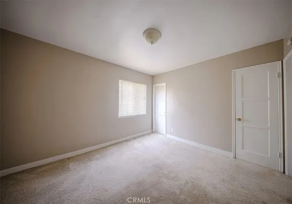 an empty room with windows and closet