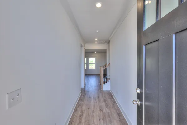 a view of a hallway with wooden floor and entryway