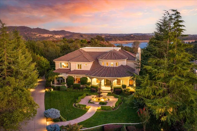 a view of a big yard with swimming pool and lawn chairs with plants