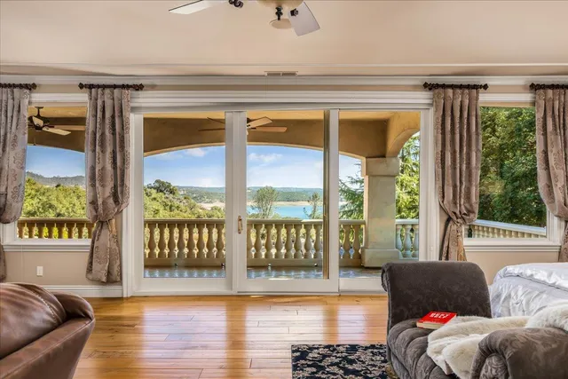 a spacious bedroom with a bed lamp and a large window