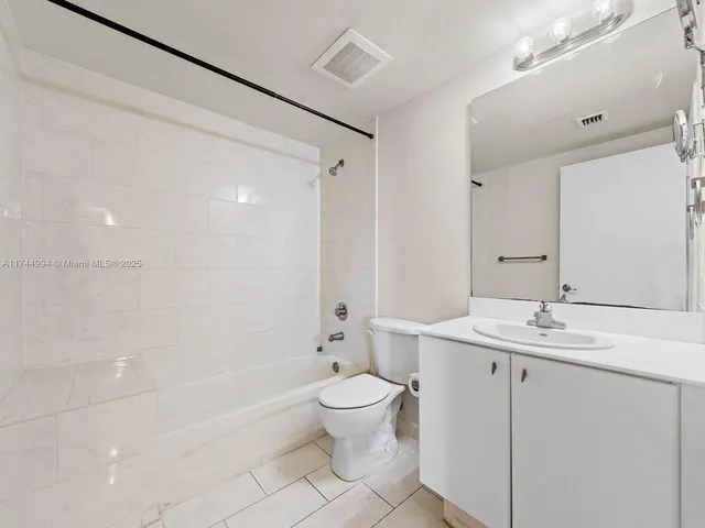 a bathroom with a sink a toilet and a large mirror