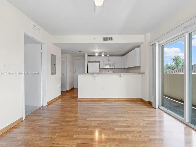 a view of a kitchen with wooden floor and a window