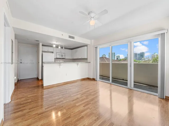 a view of empty room with wooden floor and window