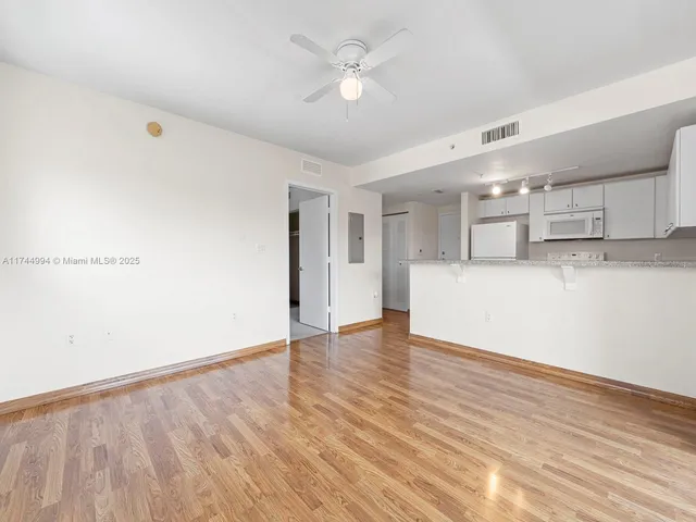 a view of a kitchen with a dishwasher and wooden floor