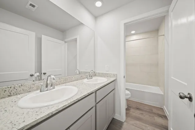 a bathroom with a granite countertop sink a mirror and a bathtub