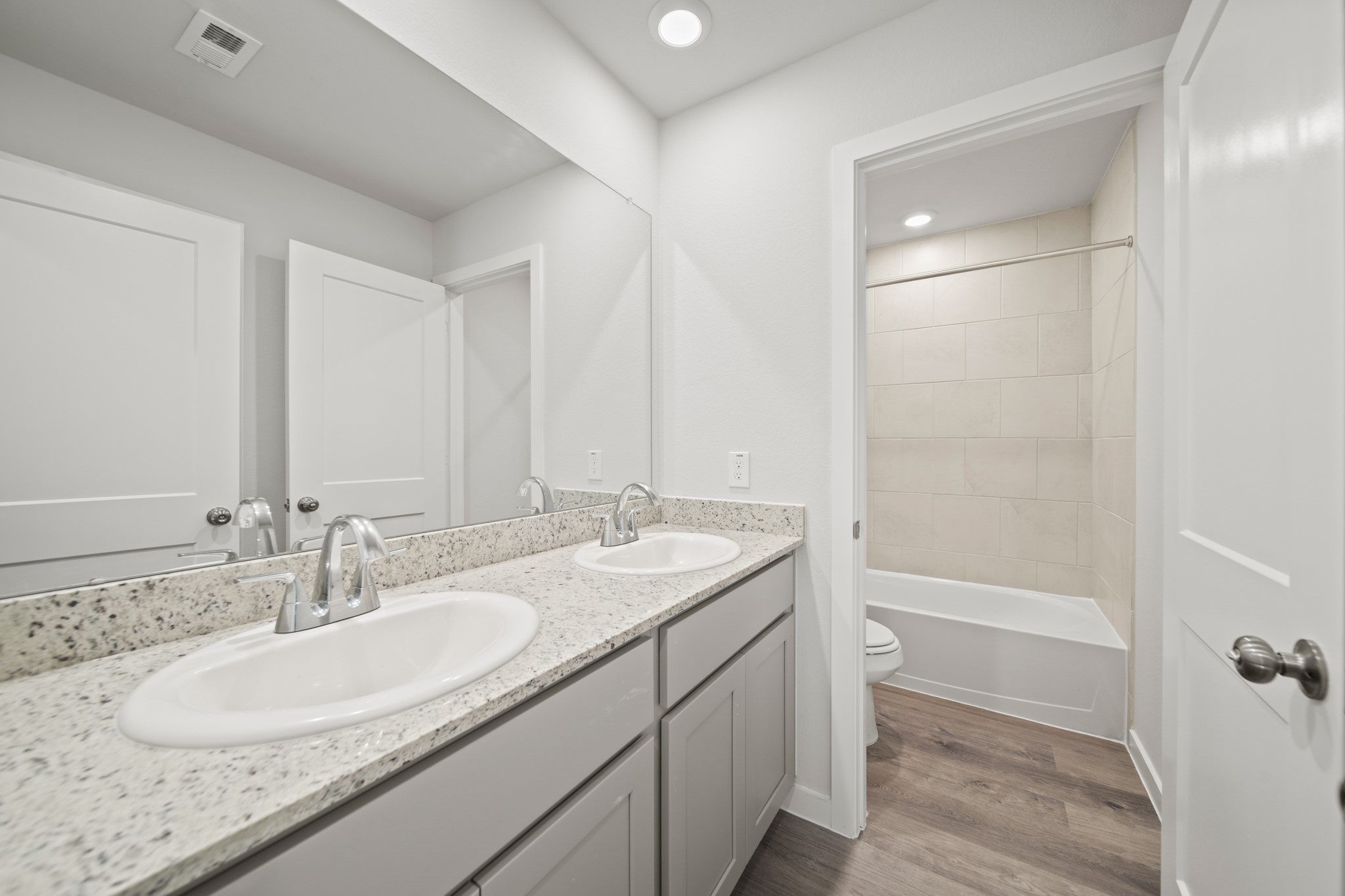 314 Bennett Street Angleton, TX 77515 - Photo 19 of 27 a bathroom with a granite countertop sink a mirror and a bathtub