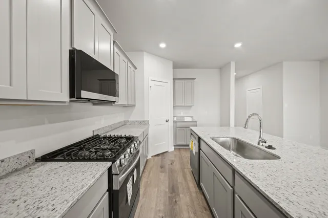 a kitchen with a sink stove top oven and refrigerator
