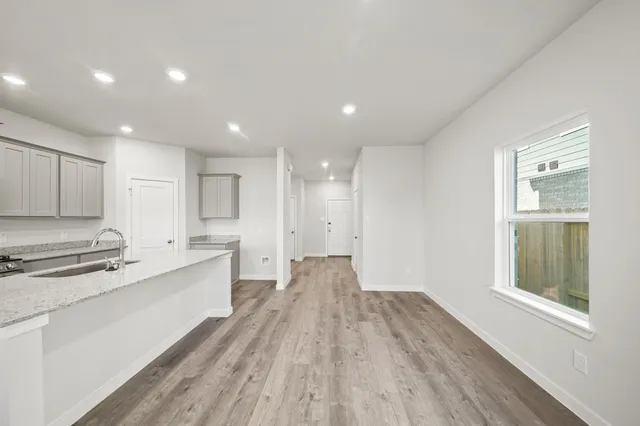 a large kitchen with a lot of counter space and wooden floor