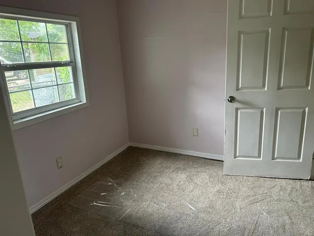 a view of a hallway with a glass door and a window