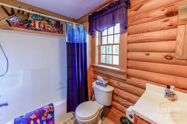 a bathroom with a toilet sink and shower curtain